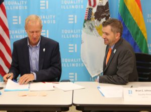 At a meeting with LGBTQ leaders in the Equality Illinois office on Sept. 28, 2017, Gov. Bruce Rauner (on left) signs ceremonial copies of pro-LGBTQ measures for Equality Illinois CEO Brian C. Johnson